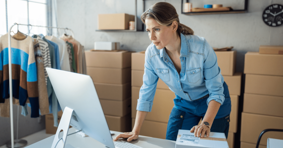 Woman managing business finances with a computer in a retail space, highlighting unsecured credit line benefits.