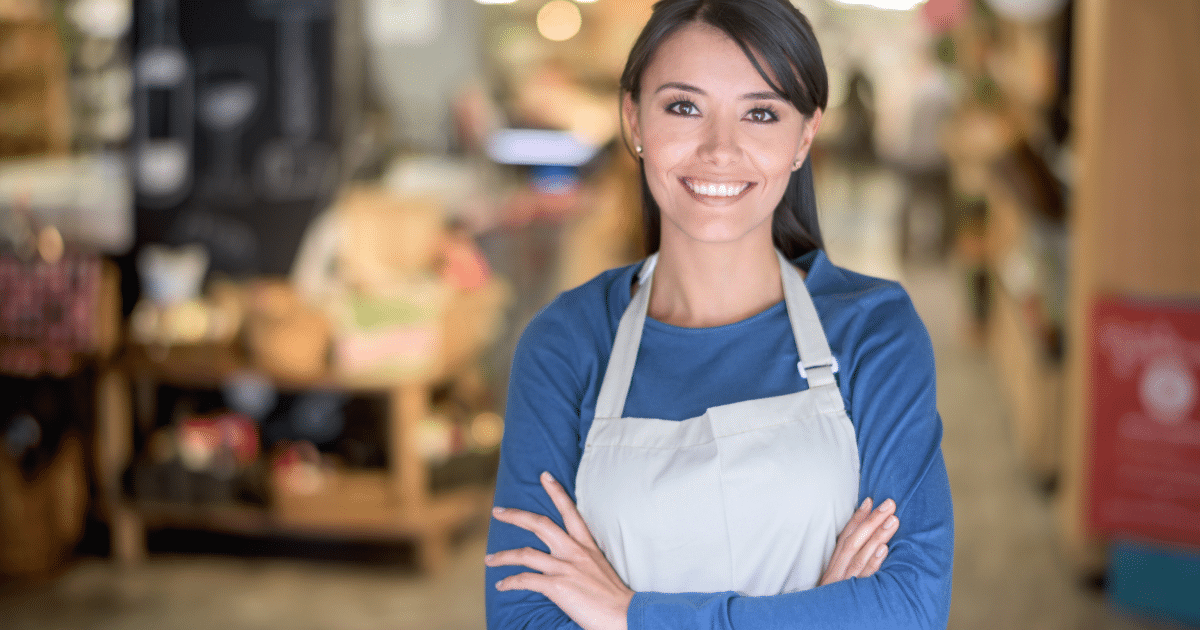 Smiling woman small business owner in an apron, representing American small businesses and entrepreneurship.