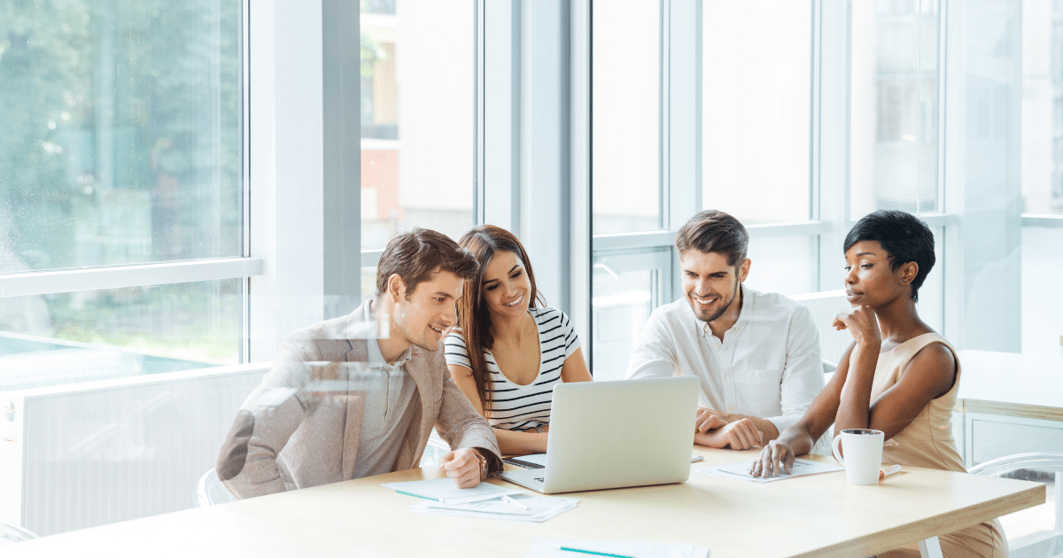 Group of young professionals collaborating on email marketing strategies for small business success in a modern office setting.