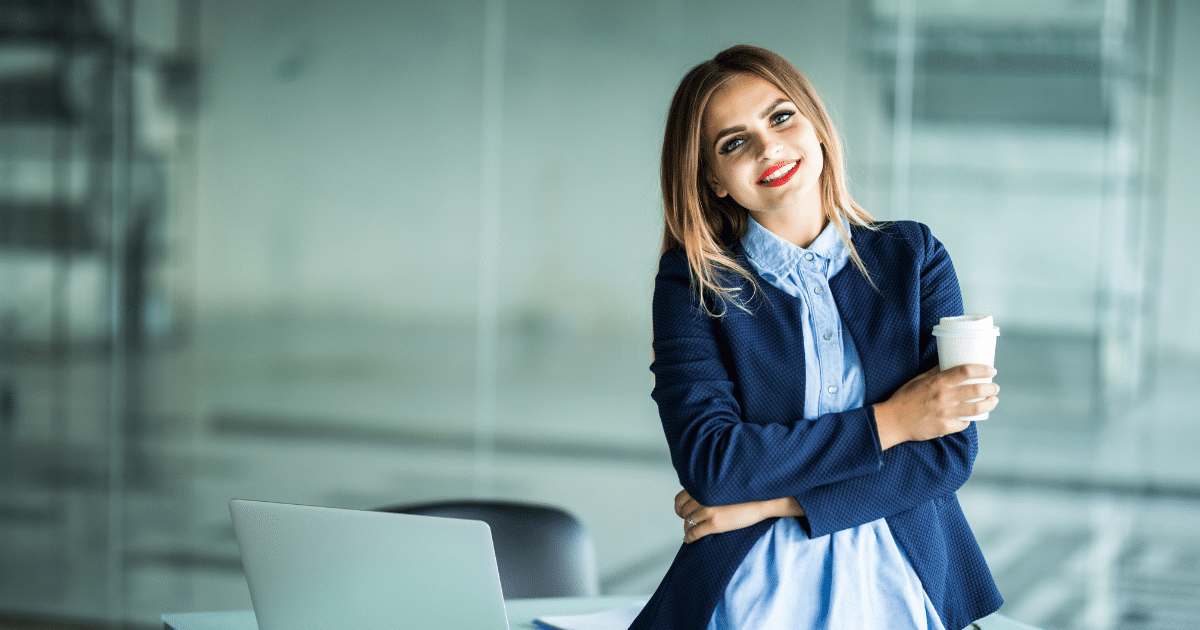 Smiling woman in a business setting holding a coffee cup, representing innovative holiday marketing strategies for restaurants.
